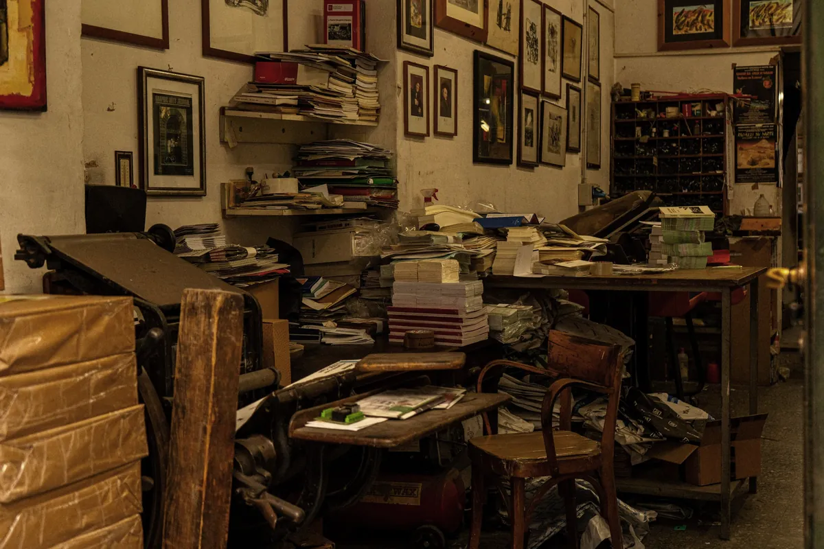 A room packed floor to ceiling with furniture, papers and boxes