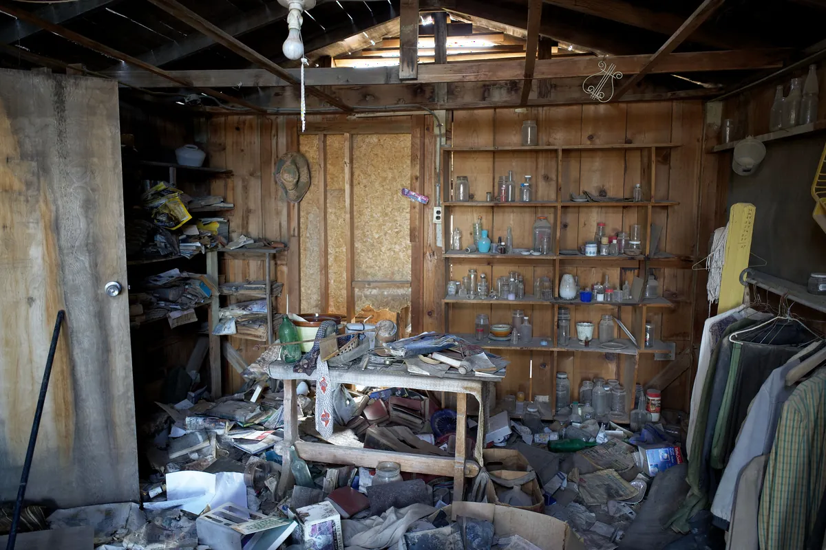 A cluttered garage shed piled with years of stored junk